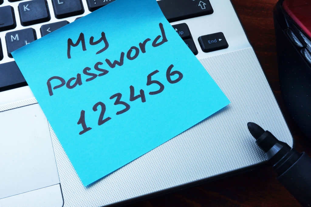 Easy Password concept. My password 123456 written on a paper. Data Room Sample displayed on a desktop computer.